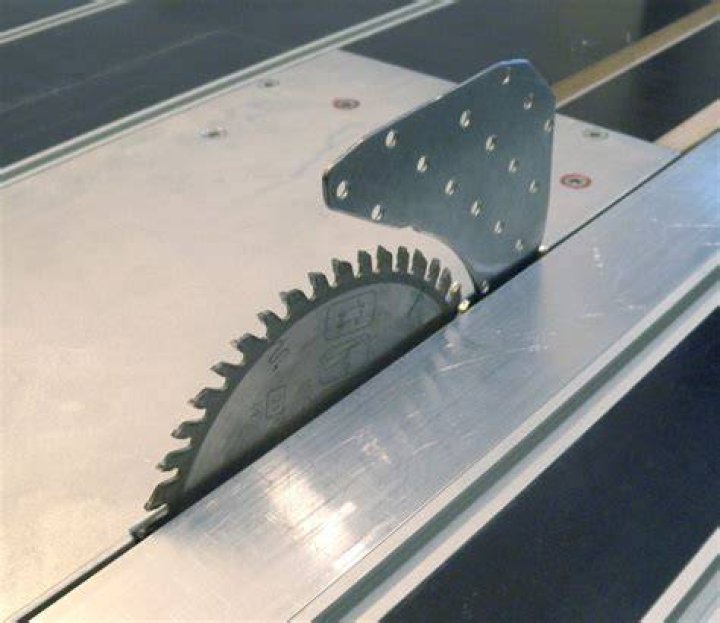 What does the spreader riving knife do on a table saw?